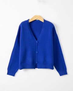 Detail of royal blue V-neck knit cardigan with three buttons on a wooden hanger