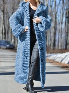 Detail view of heavy knit texture and buttons on a hooded blue cardigan sweater coat