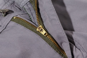 Makro-Detail des hochwertigen Metallreißverschlusses und Druckknopfs an der Cargo-Shorts