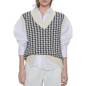 Detail of V-neck knitted vest with black and white houndstooth pattern and ribbed edges