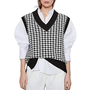 Close-up of stylish V-neck knitted vest featuring a classic black and white houndstooth pattern