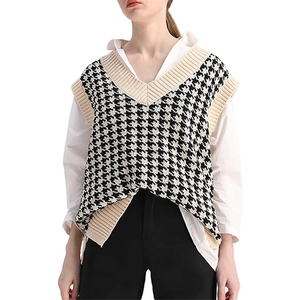 Detail of V-neck knitted houndstooth vest layered over a white shirt with ribbed edges
