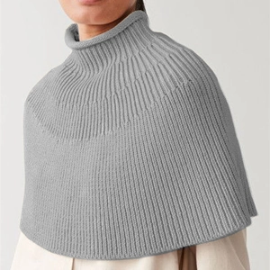 Detail of grey high-neck knit poncho showing fine vertical ribbed texture and minimalist style