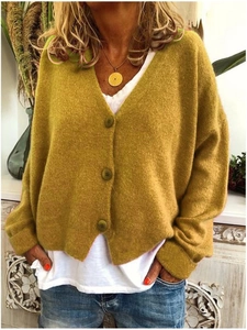 Detail of loose-fit V-neck ginger knit cardigan with three matching round buttons