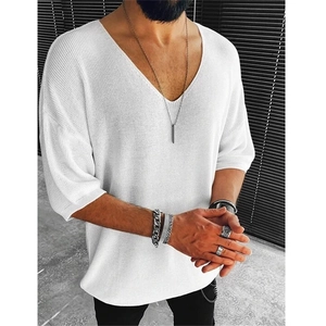 Detail of white knit V-neck T-shirt with fine texture and loose drop shoulder design