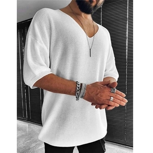 Close-up of a white men's V-neck knit shirt showing detailed fabric texture and fit
