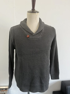 Detailed close-up of dark grey thick knit sweater featuring a shawl collar and wooden button