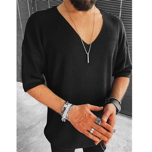 Close-up of black V-neck knit shirt showing soft fine texture and slim-fit sleeve detail
