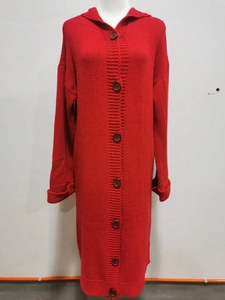 Detail view of red knitted hooded cardigan with brown buttons and folded cuffs