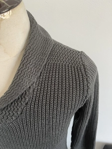 Close-up of dark grey high-neck sweater with vertical ribbing and knit texture