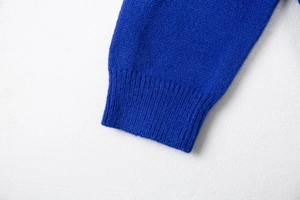 Close-up of Klein Blue ribbed cuffs on a V-neck knitted cardigan with soft texture