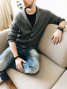 Close-up of grey shawl collar cardigan featuring thick rib-knit texture and black buttons