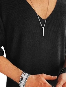 Detail of black V-neck knit shirt with minimalist silver necklace and stacked bracelets