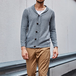Detailed texture of men's grey shawl collar knit cardigan with classic cable patterns