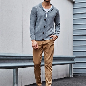 Detail of grey cable knit cardigan with shawl collar and dark resin buttons