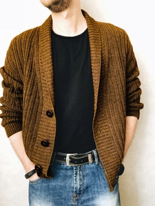 Detail view of coffee-brown chunky knit cardigan with large buttons and textured fabric