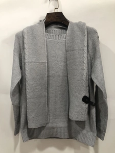 Detail of grey knitted sweater with detachable scarf showing texture and button details