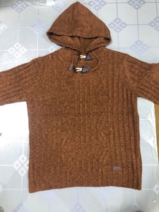 Detailed cable knit pattern and toggle button closure on hooded caramel sweater