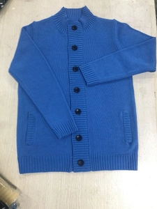 Detail view of royal blue knit cardigan with ribbed cuffs and textured button-down design