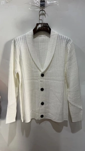 Close-up of white waffle knit cardigan with shawl collar and black buttons