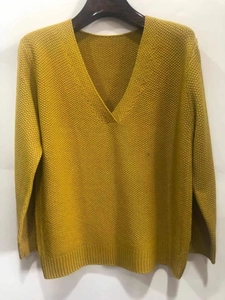 Detailed close-up of the honeycomb knit texture and rib-knit cuffs on this V-neck sweater