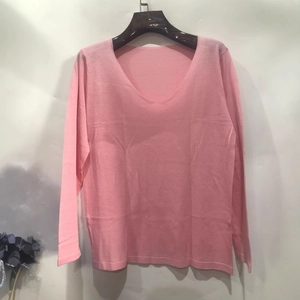 Close-up of pink V-neck knit sweater featuring lightweight fabric and long sleeve details