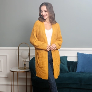 Macro view of mustard yellow knit cardigan featuring waffle texture and large pockets