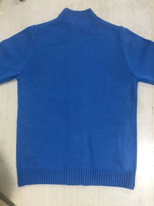 Back view of bright blue knit cardigan featuring ribbed cuffs and a stand-up collar design