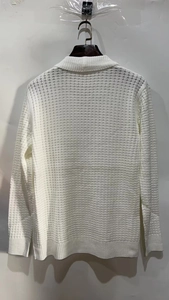 Macro shot of white long sleeve waffle knit polo sweater showing detailed fabric texture
