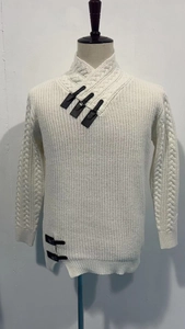 Detail of cream cable knit sweater showing stylish leather buckle closures on the high collar