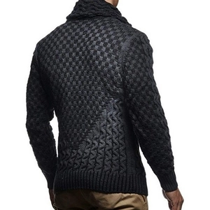Macro shot of dark grey knit sweater back showing waffle texture and cable stitch details