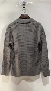 Close-up of charcoal grey waffle knit texture and ribbed cuffs on men's cardigan