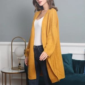 Detail of chunky mustard yellow knit cardigan featuring large pockets and honeycomb texture