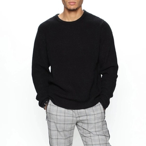 Close-up of a men's black crewneck sweater featuring a textured waffle knit fabric
