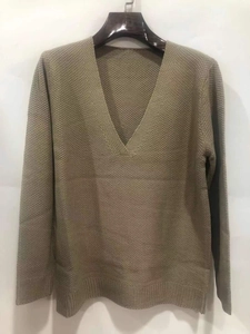 Macro detail of men's V-neck sweater featuring textured waffle knit and ribbed cuffs