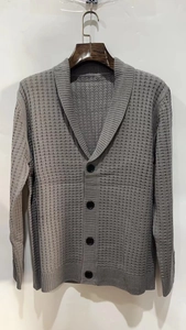 Close-up of grey shawl collar knit cardigan showing waffle texture and black buttons