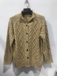 Detail of beige cable knit cardigan featuring a stand collar and dark buttons close-up