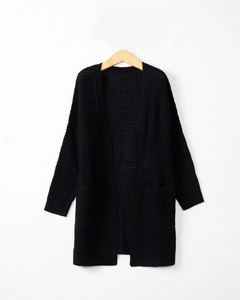 Detail of waffle knit texture and large front pockets on a black long cardigan sweater