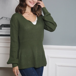 Détails de texture du pull en maille vert olive avec col en V et taille à volants