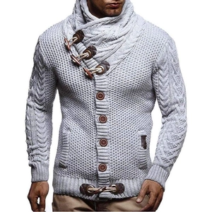 Detail of light grey knit cardigan with cable pattern and toggle button collar