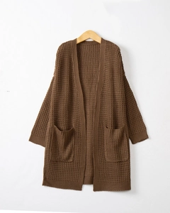 Close-up of deep brown long-sleeved waffle knit cardigan with detailed front pockets