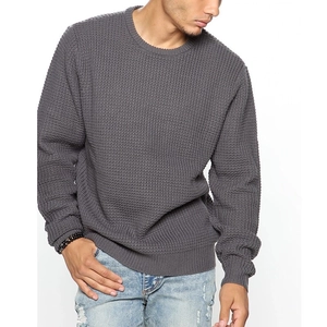 Detail of grey waffle knit texture on men's long sleeve crewneck sweater and ribbed cuffs