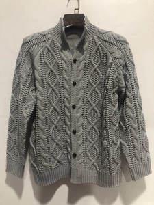 Close-up of cable knit patterns and vintage buttons on a gray cardigan sweater