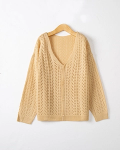Detail of V-neck knitted cardigan with intricate pointelle pattern and matching buttons