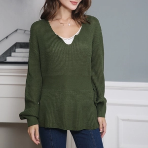 Détail du pull en tricot vert foncé à col en V avec taille volantée et texture gaufrée