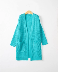 Detail of teal waffle knit cardigan showing thick texture and large square pockets