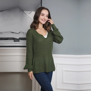 Détail pull en maille vert foncé col en V avec taille volantée et poignets bouffants