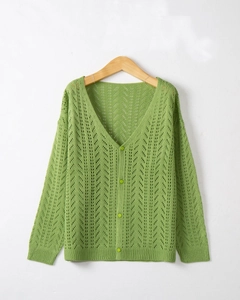 Detail of green pointelle knit cardigan featuring V-neckline and matching round buttons