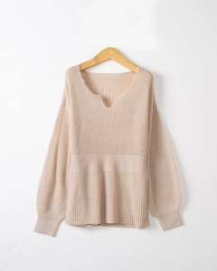 Détail de l'encolure en V et texture tricotée verticale sur un pull de couleur crème