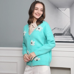 Dettaglio del cardigan verde menta con applicazioni floreali 3D e scollo a V con bottoni